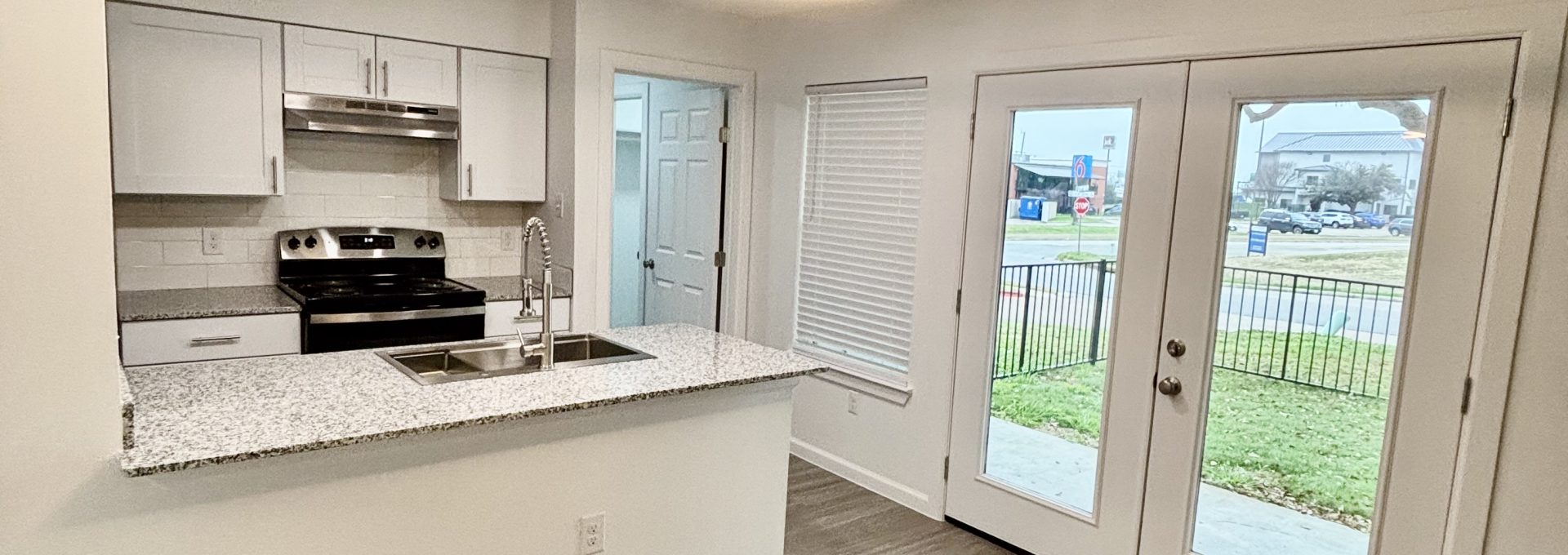 a kitchen with white cabinets and hardwood floors at The 3001 Crystal Springs